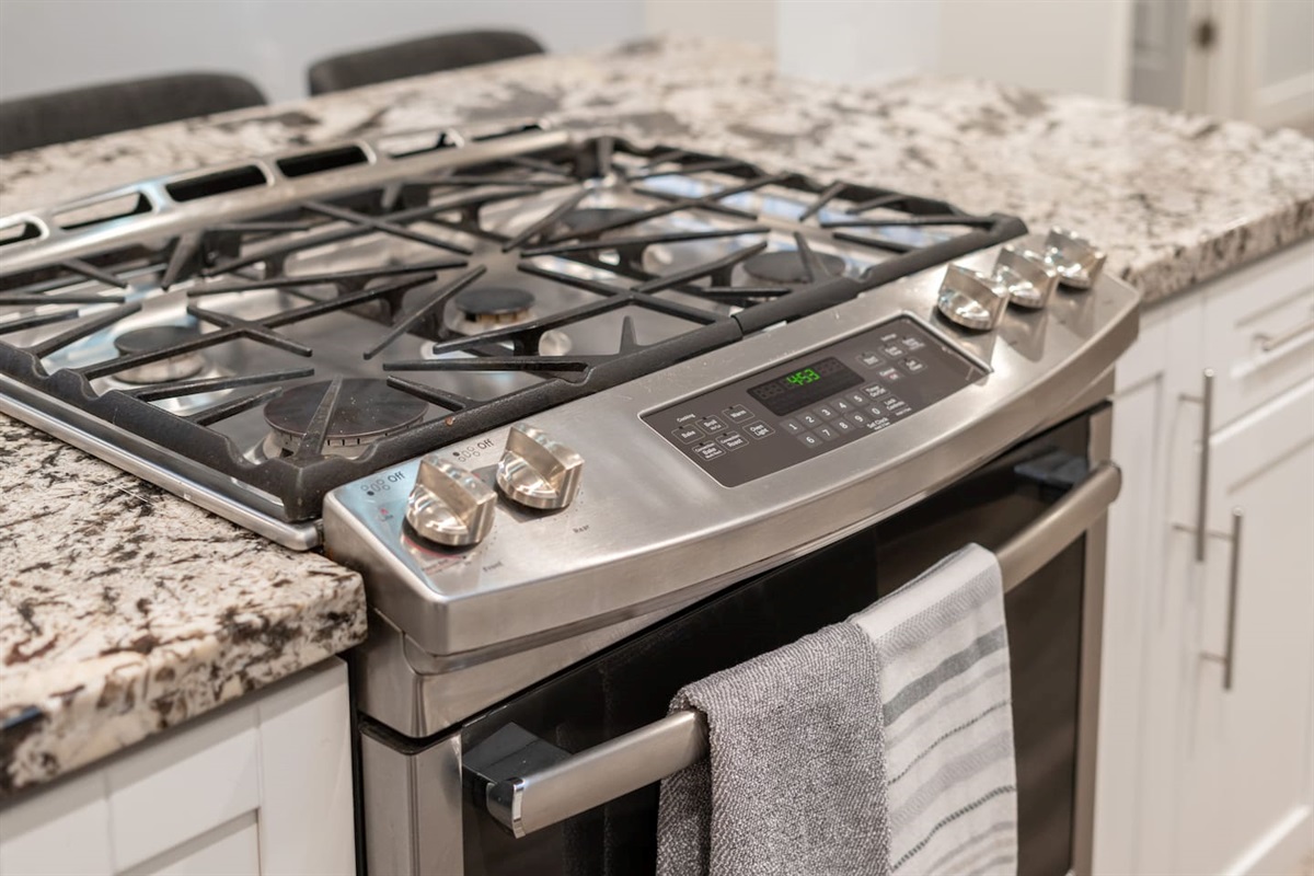 Stainless steel gas stove with built-in oven, featuring a sleek design and modern functionality for all your cooking needs.