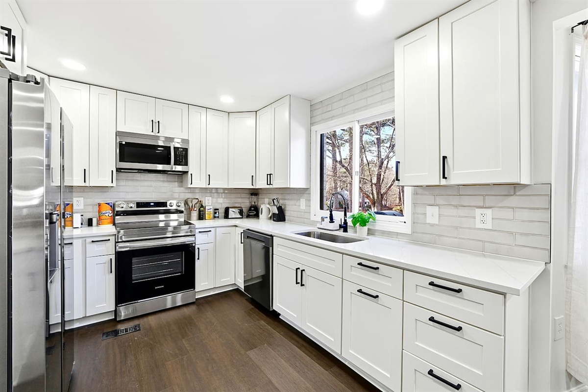 Bright white kitchen with a sleek, extended layout and ample counter space. The long layout offers plenty of countertop space, perfect for cooking, prepping, and everyday meals. Fully stocked with everything you need for a comfortable stay!

