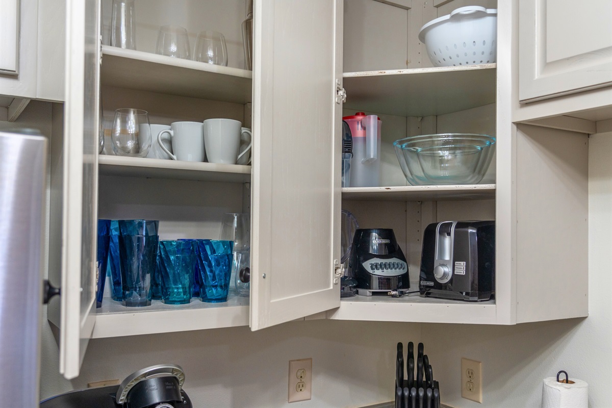 Open cabinets stocked with sparkling glassware and drink essentials ensure you have everything you need for a refreshing drink or a cozy evening in.