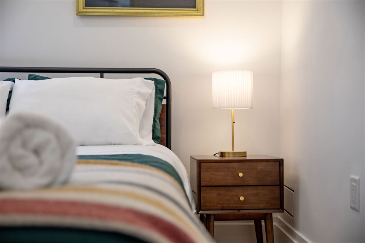 A stylish bedroom side table with a sleek lamp, adding both functionality and a soft, warm glow to the space for reading or creating a cozy ambiance.
