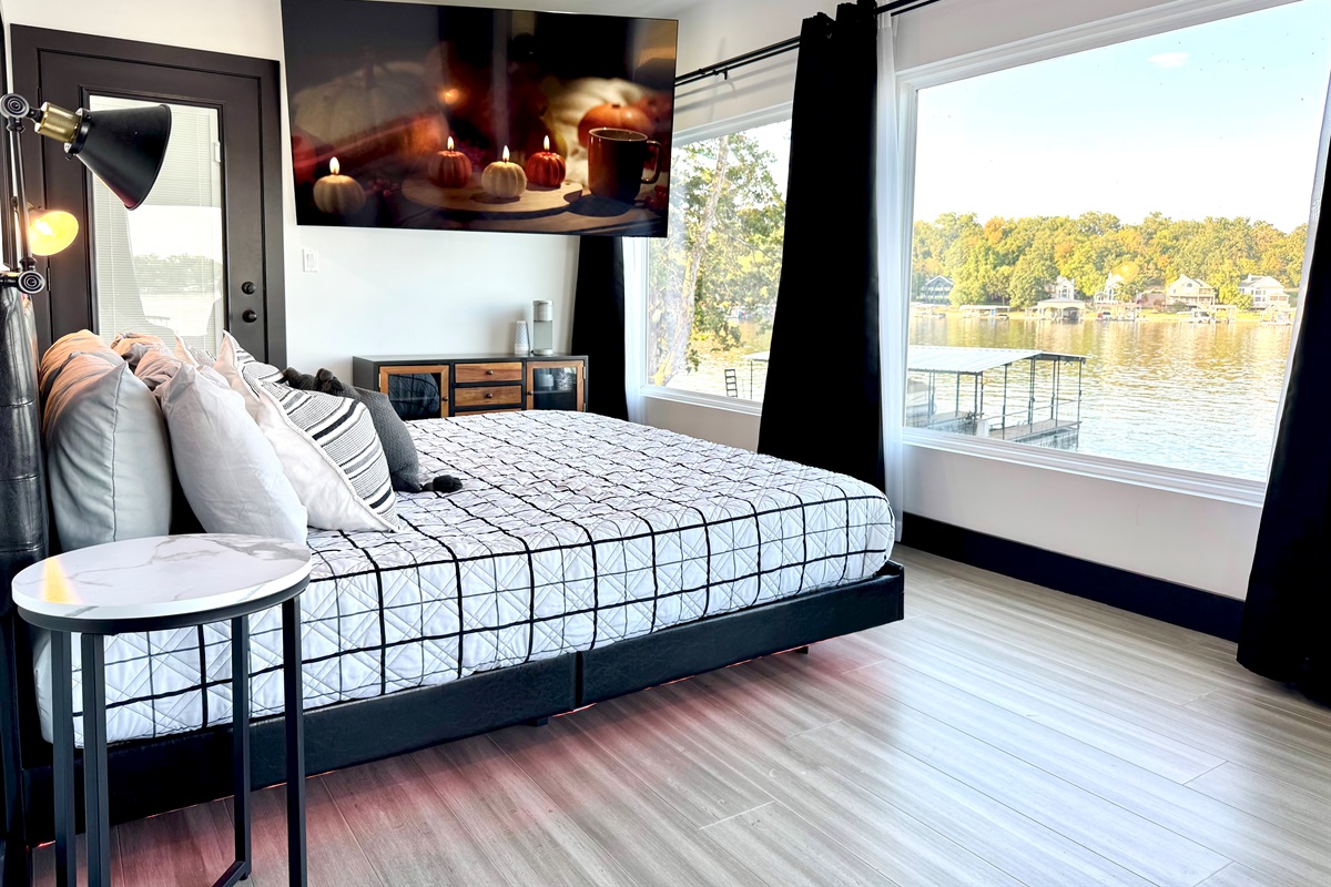 Primary Bedroom has king bed with an ensuite bathroom, 85" TV, Kuerig coffee maker, and private balcony access.