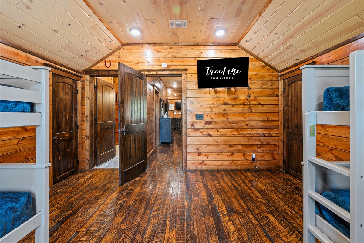 A view down the hallway highlights the cabin’s open flow and consistent design, making it easy to move between rooms while enjoying the rustic charm throughout.