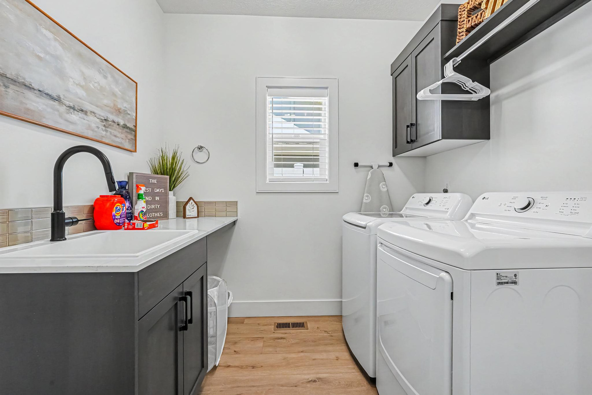 A bright and spacious laundry room with a garage entry door, utility sink, and everything you need for a comfortable stay.