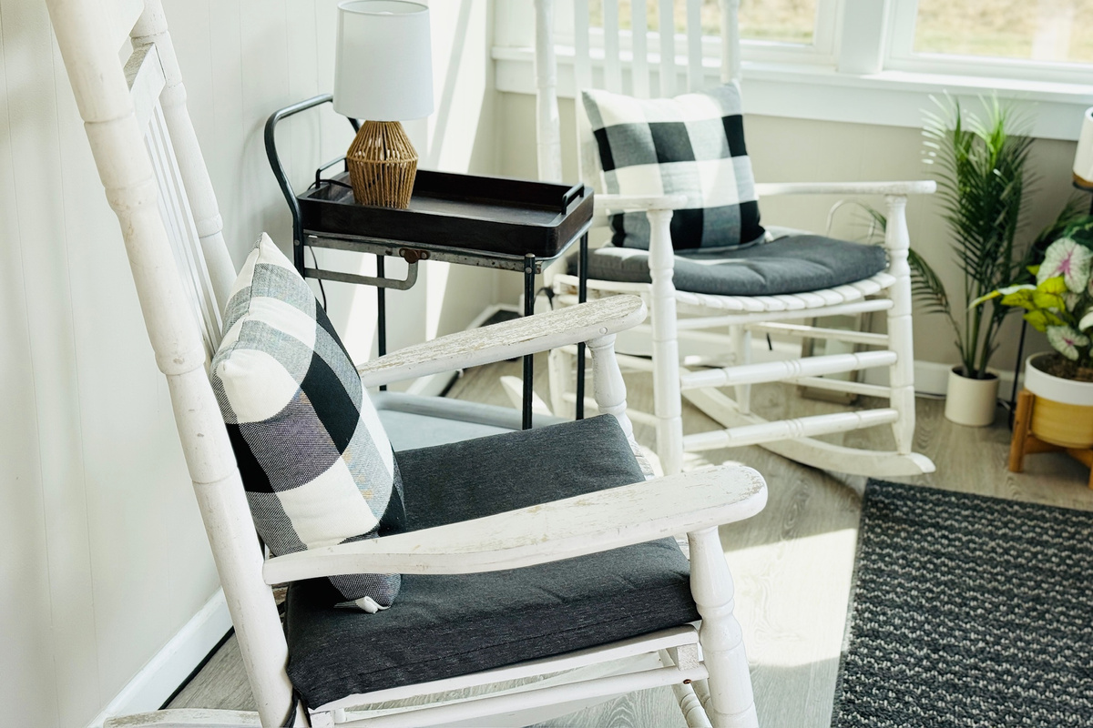 Enclosed sitting area with rocking chairs and abundant natural light.