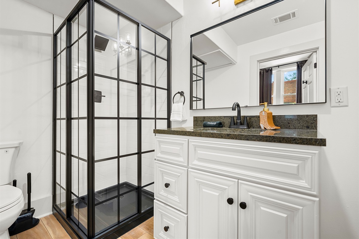 The modern bathroom features a walk-in shower and stylish fixtures, offering the perfect space to refresh and unwind after a day of exploring.