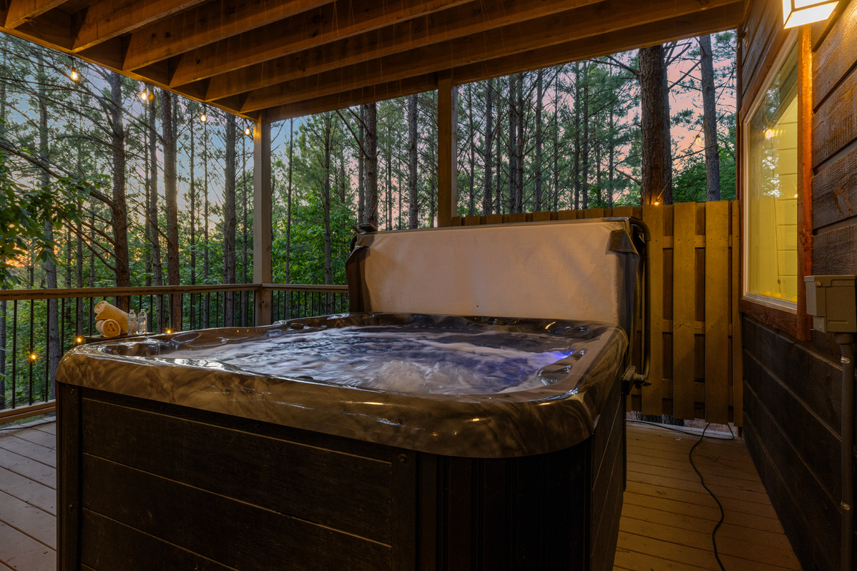 Relax in the private covered hot tub surrounded by towering pines and twinkling string lights. The perfect spot to unwind, soak, and enjoy the peaceful beauty of the forest. 🌲✨🛁