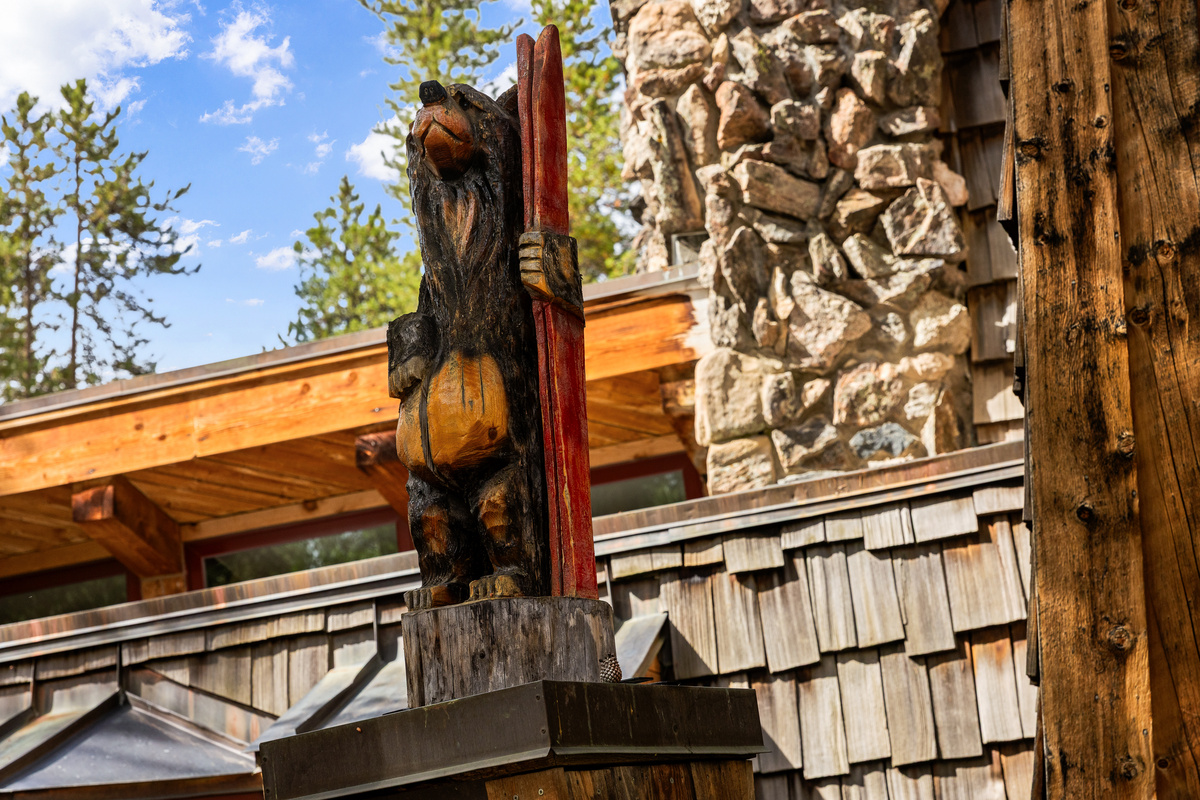 A classic ski lodge carved wooden bear greets guests at front entrance to Arrow Darrow. 