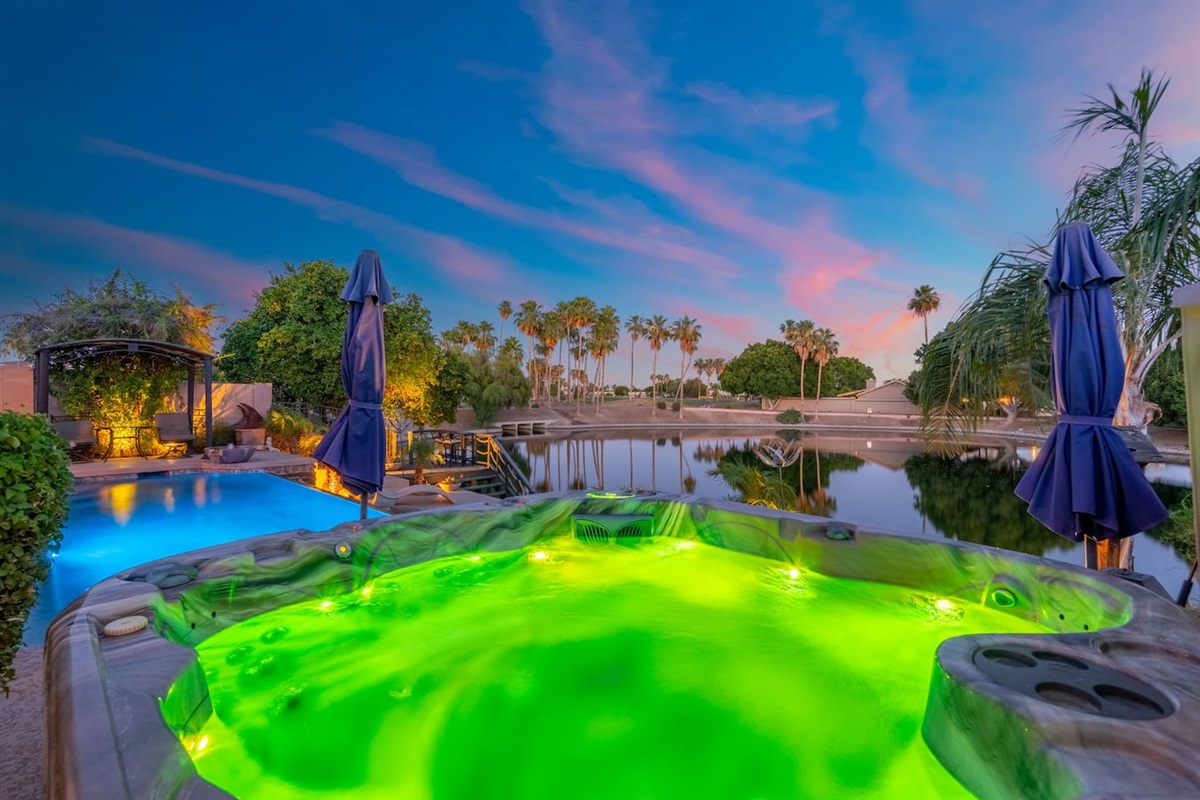 Hot tub glowing, pool lit up, lake shimmering, and a sunset that stops your mid-sentence — the backyard puts on a show every single evening.