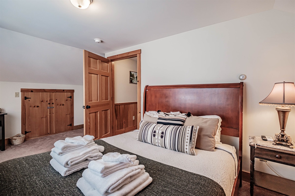 Second-floor queen bedroom with a comfortable queen bed, cozy crib, and convenient workspace.