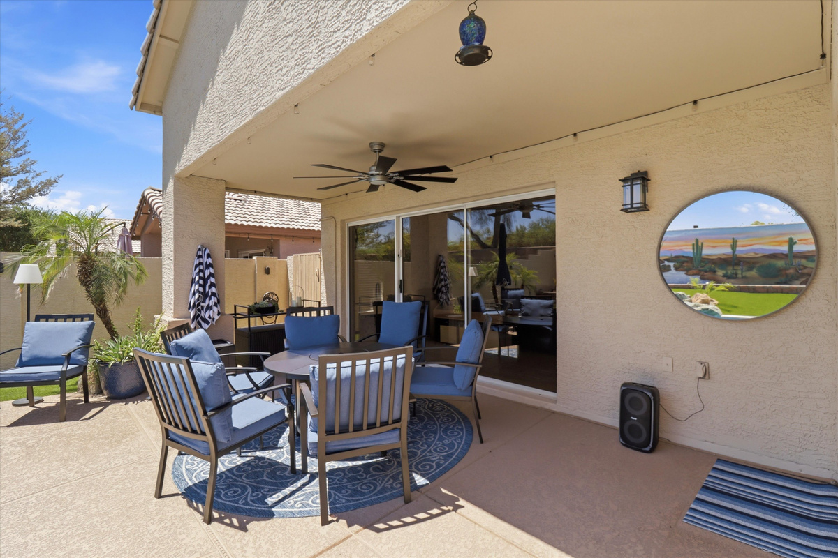 Covered patio seating with pool views, ceiling fan, and shaded space for outdoor meals or relaxed downtime.