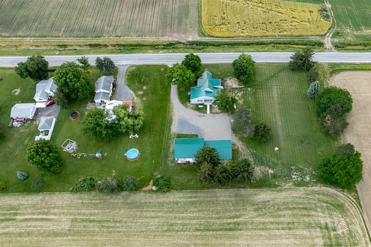 Bird’s-eye view of a well-maintained rural retreat with a long driveway, expansive lawn, and plenty of privacy from neighboring homes.