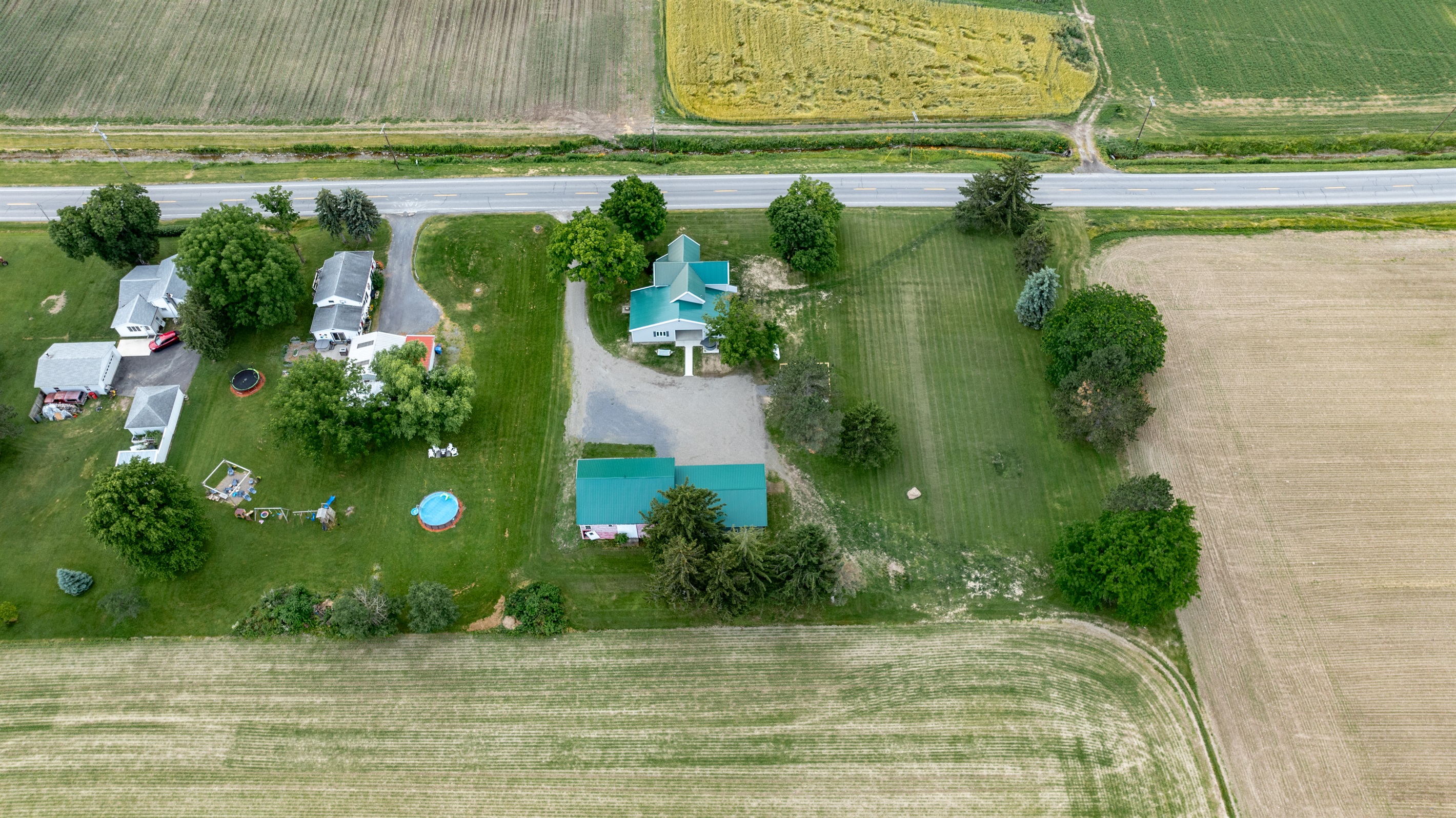 Bird’s-eye view of a well-maintained rural retreat with a long driveway, expansive lawn, and plenty of privacy from neighboring homes.
