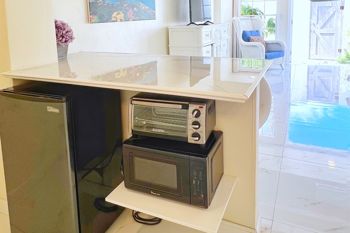 Compact kitchenette featuring a microwave and mini-fridge for snacks.