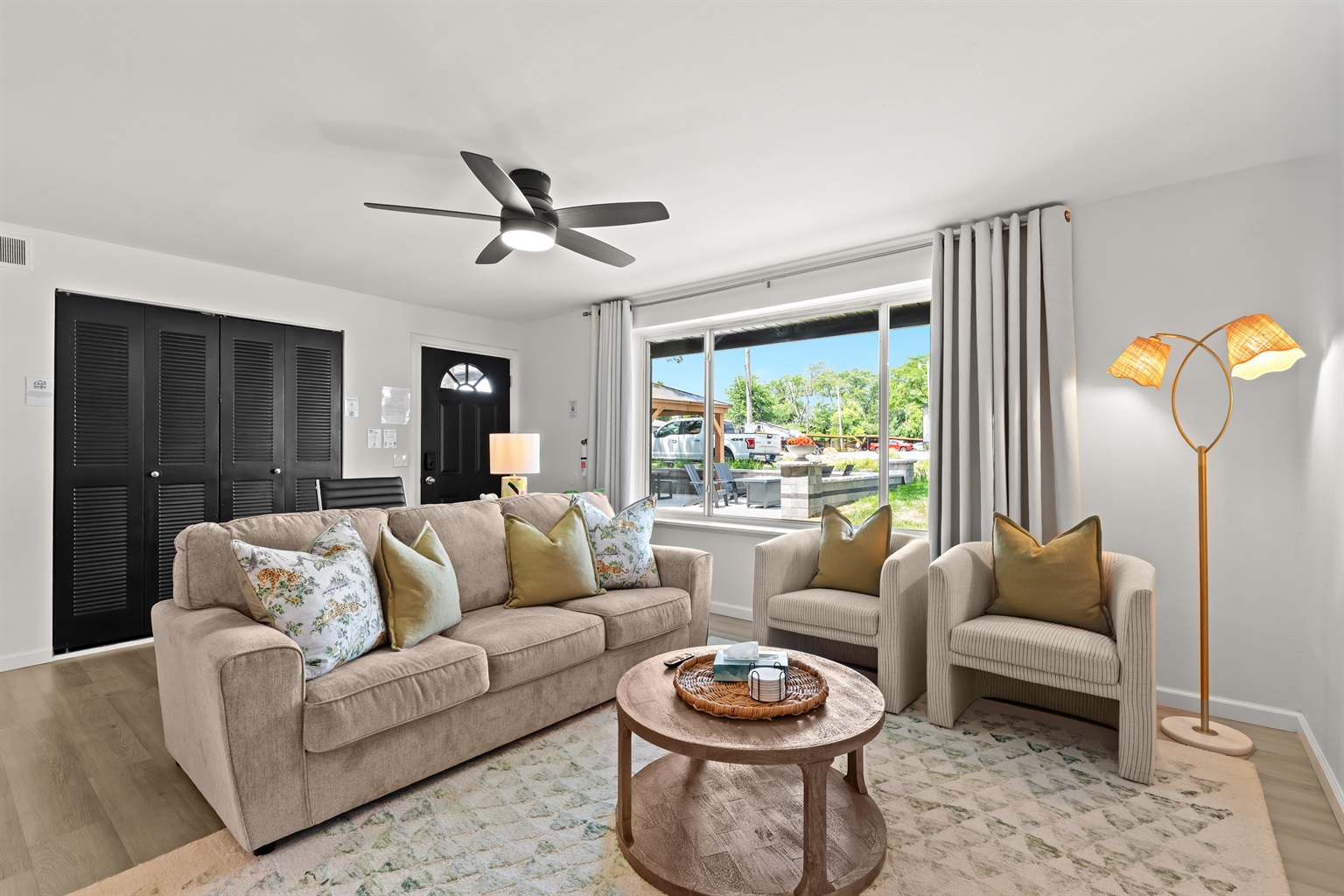 Bright and welcoming, this living area features a large window, comfy seating, and charming pillows for the perfect home-away-from-home vibe.