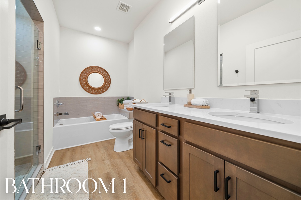 Bathroom 1: Luxurious space with double vanity, soaking tub, and walk-in shower.