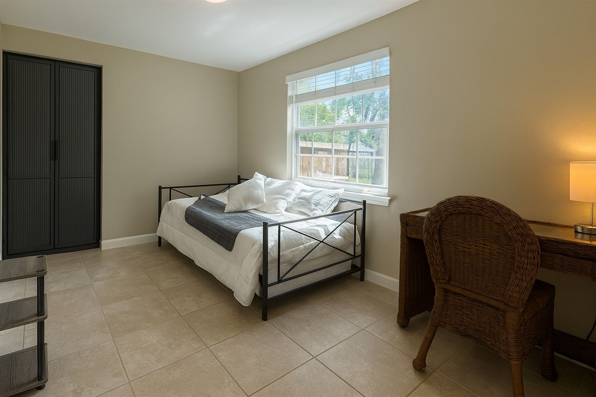 Peaceful bedroom with a stylish metal-frame queen bed, workspace and ample closet—ideal for remote work or rest after sunny days at Madeira Beach and adventures at Johns Pass in Seminole, FL.