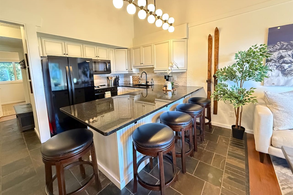 Kitchen & Dining Overview: The sleek kitchen features a large island that seats 5 and quality Whirlpool appliances, including a modern glass top stove and side-by-side fridge, at your Kimberley rental.
