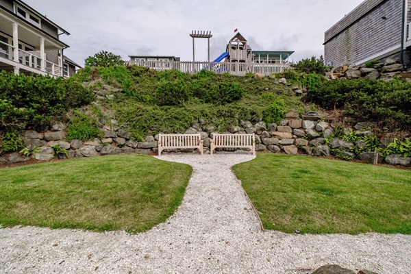 A peaceful garden path and seating area right beside the home—perfect for reading, picnicking, or enjoying the ocean breeze. 