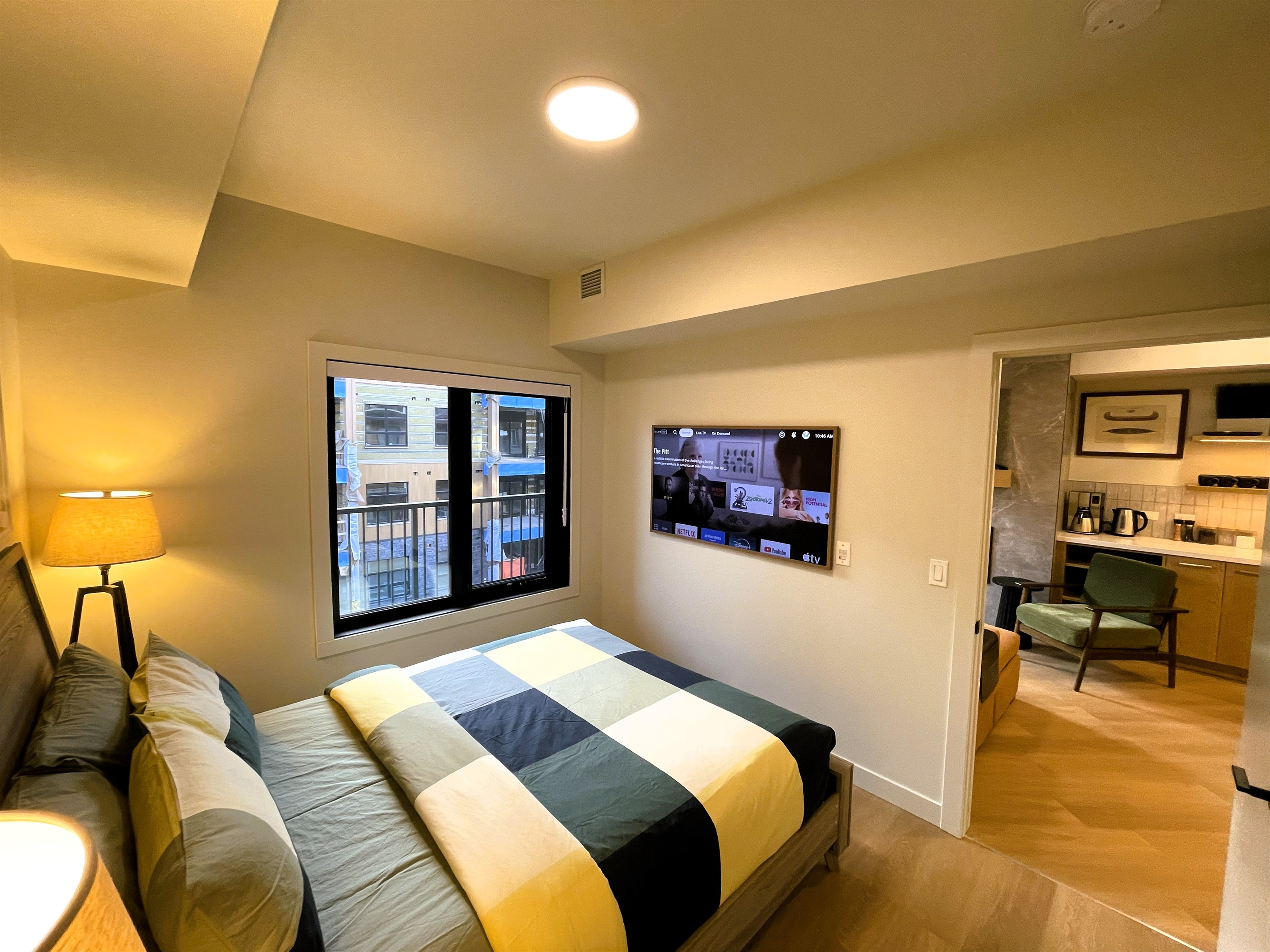 Main bedroom, with a 55" picture frame TV. You can see the kitchen area through the door. Lots of storage including two closets, and a wardrobe. Central heating and air conditioning. 