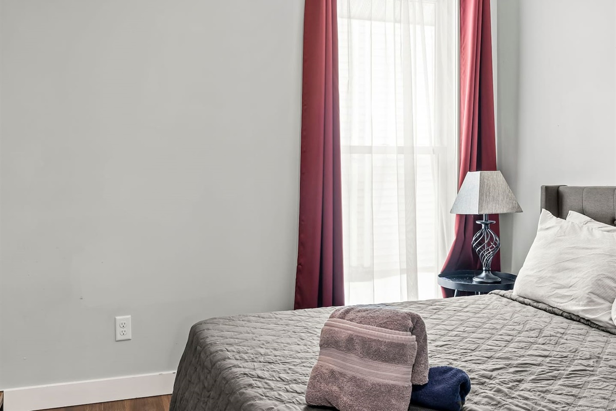 Detailed bed view highlighting plush pillows, quilted bedding, and a calm, neutral design.