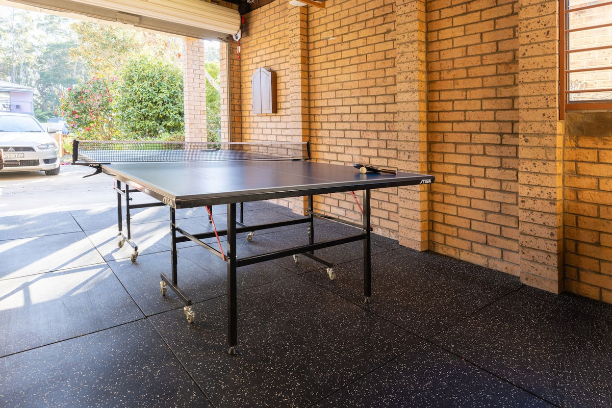 The garage games area at Luna’s Sanctuary features a table tennis setup, open floor space and brick surrounds for casual indoor activity.