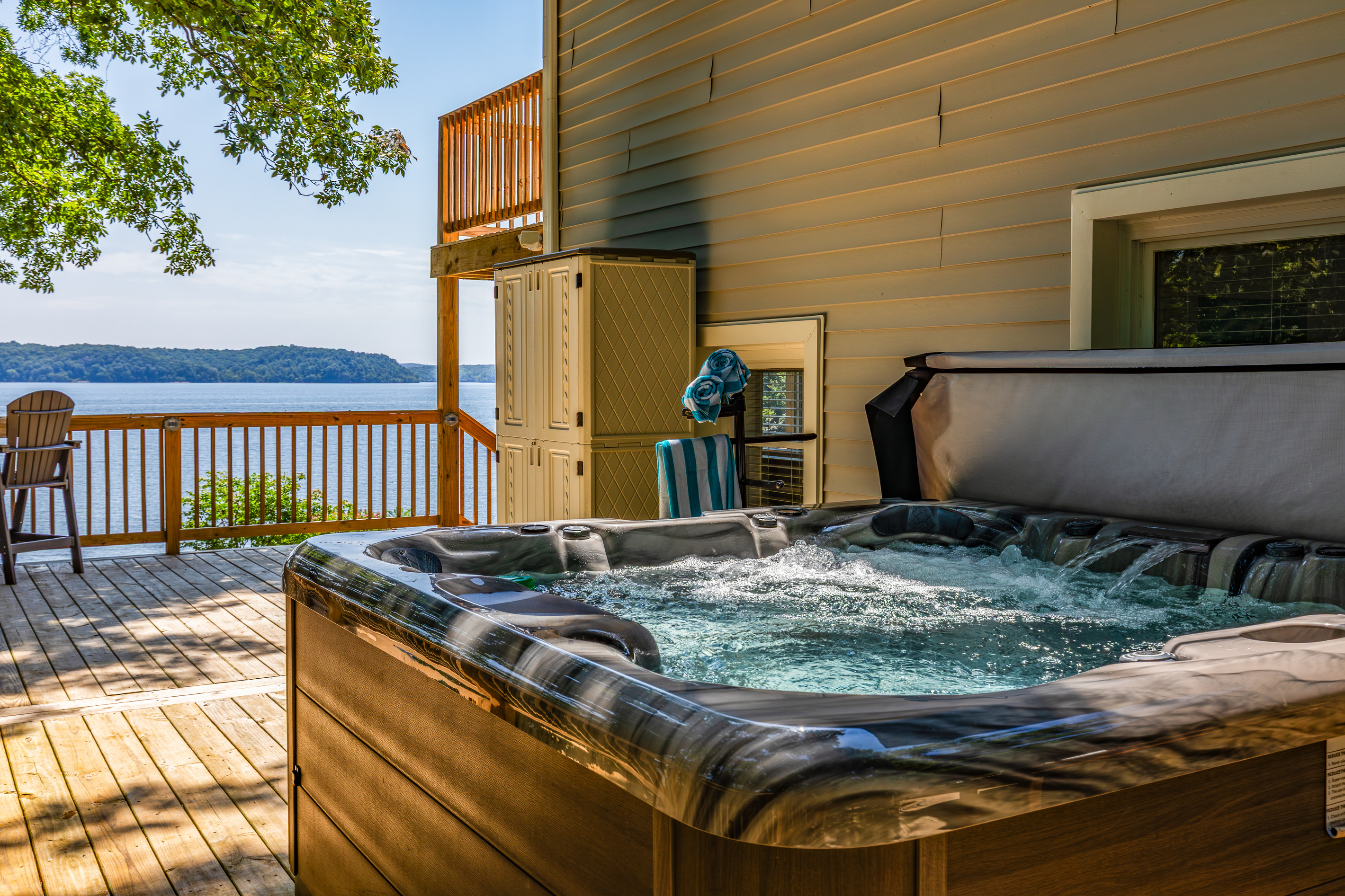 A second hot tub angle highlights the water view and spacious outdoor deck.