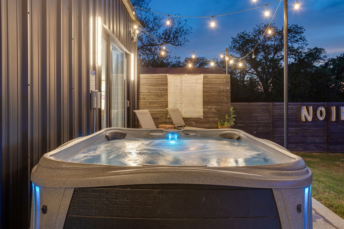 Outdoor hot tub with string lights at The Noir, a luxury Lake Granbury vacation rental with private pool and waterfront access.