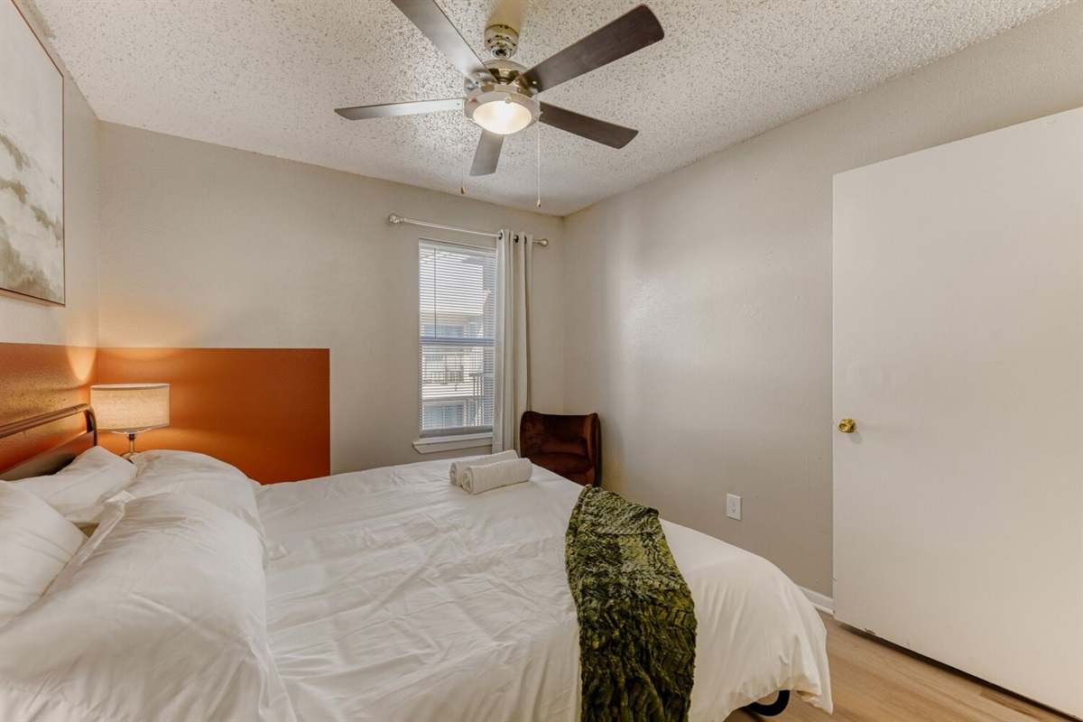 Cozy bedroom with warm lighting, simple decor, and a comfortable bed.