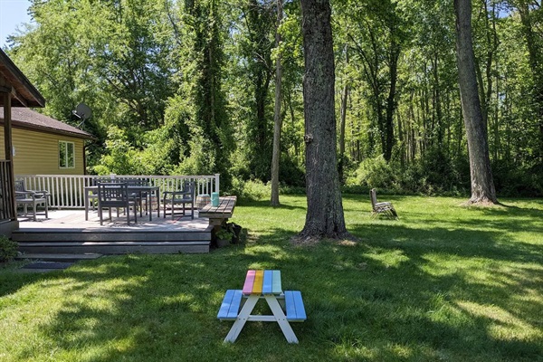 Side view of back yard. Children's picnic table in the foreground.