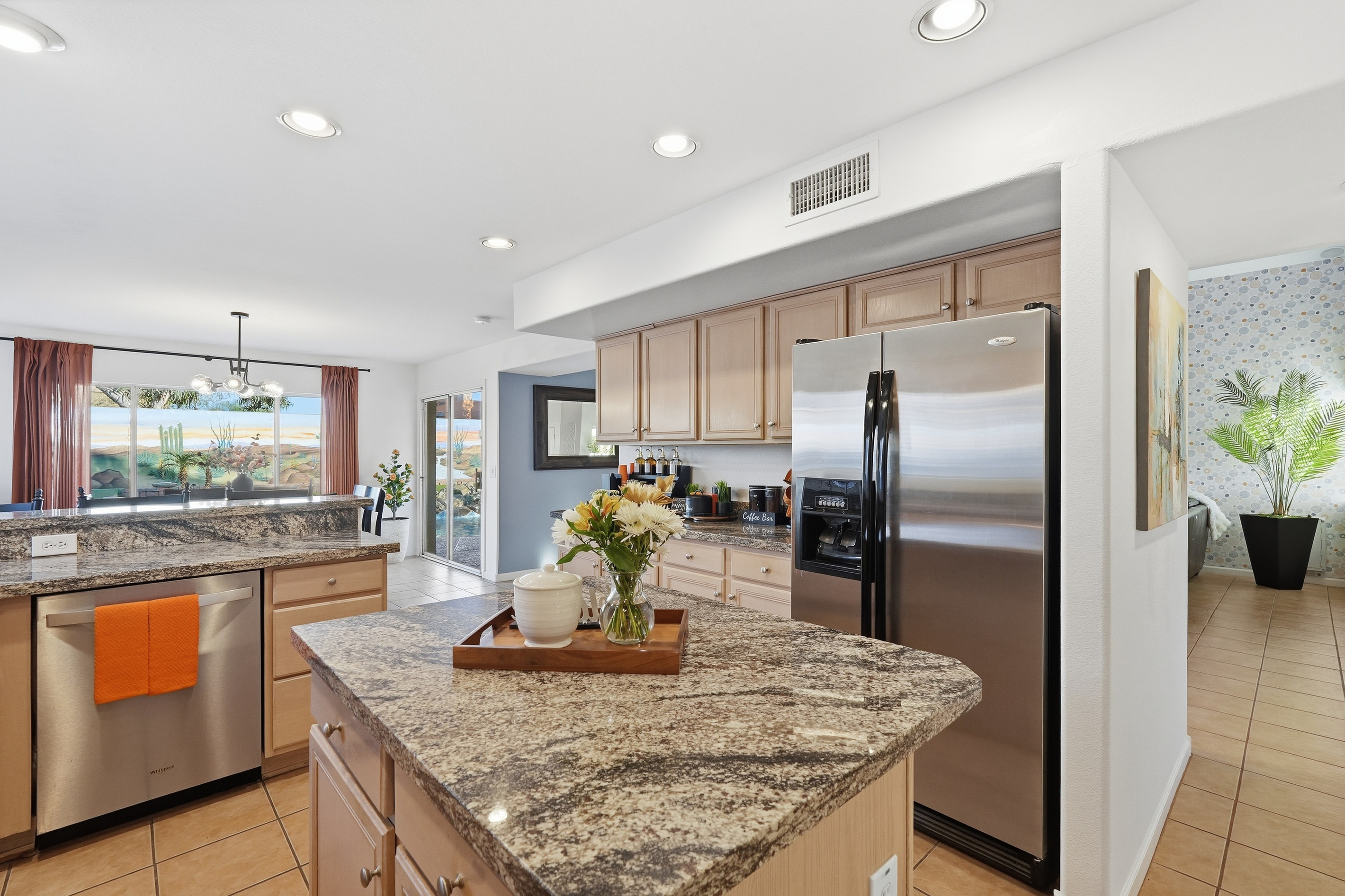 Full kitchen with granite island, appliances, dishwasher, and open flow to the dining and living areas.