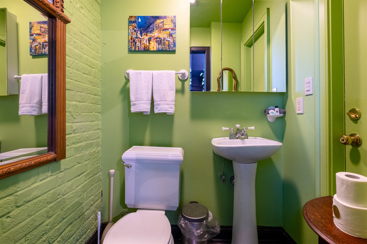 Additional bathroom view with pedestal sink, mirror, and vibrant accent walls.