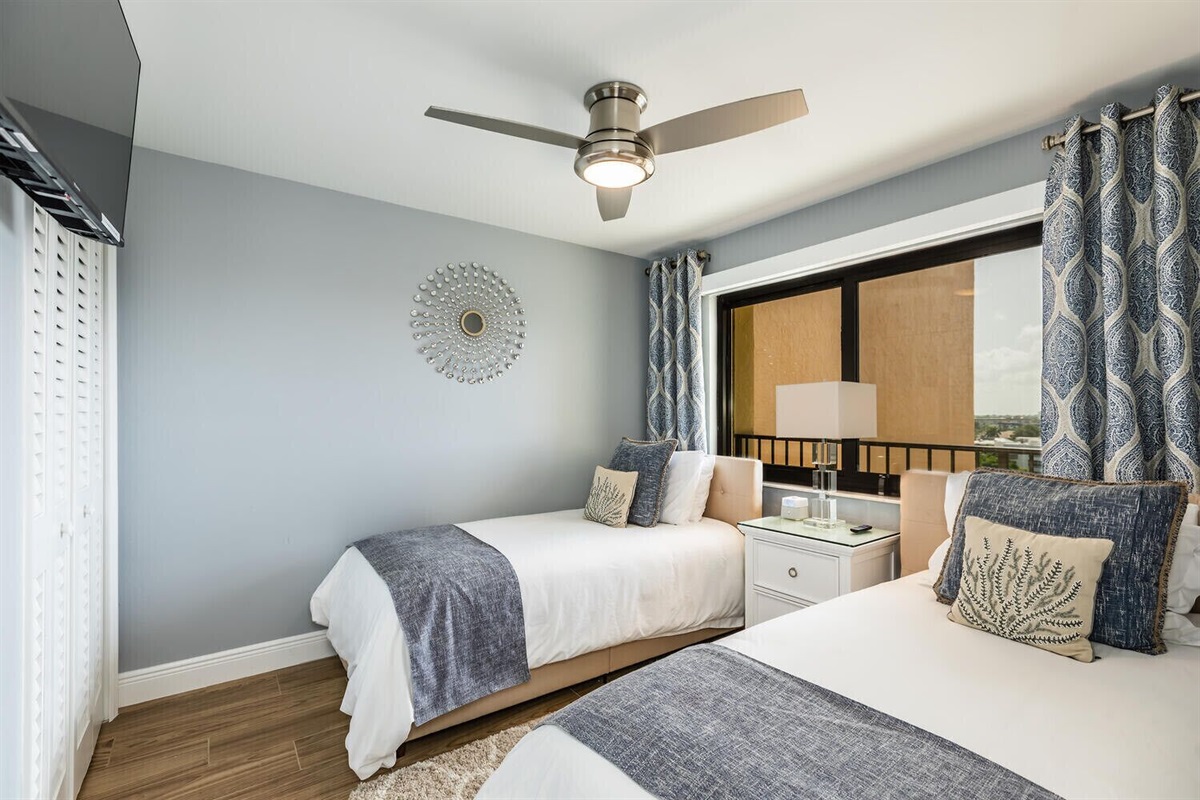 Two twin beds, black out shade on new hurricane window & Roku TV on wall