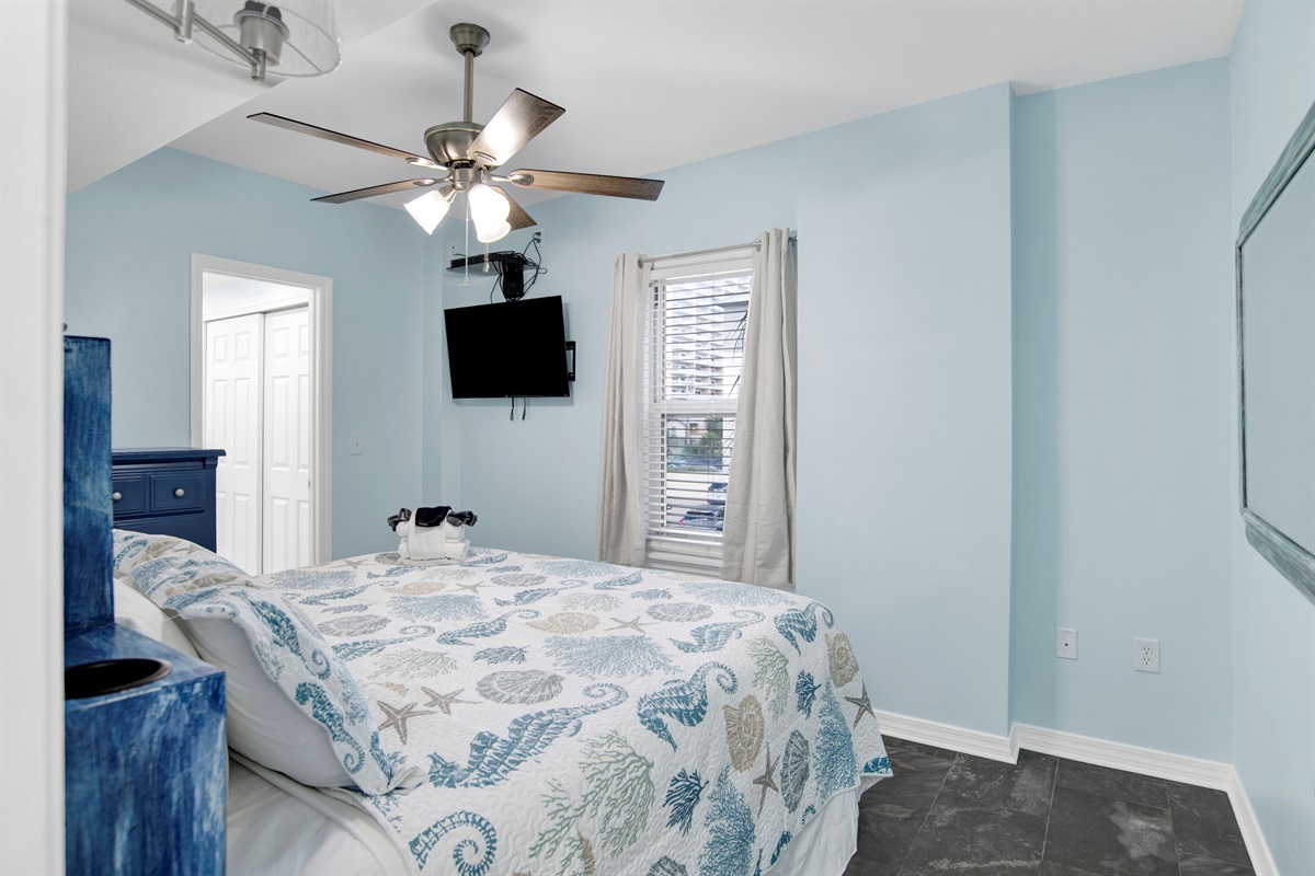 Primary Bedroom has a King bed with built in side tables, ceiling fan, wall mounted smart TV, chest of drawers and en-suite bathroom