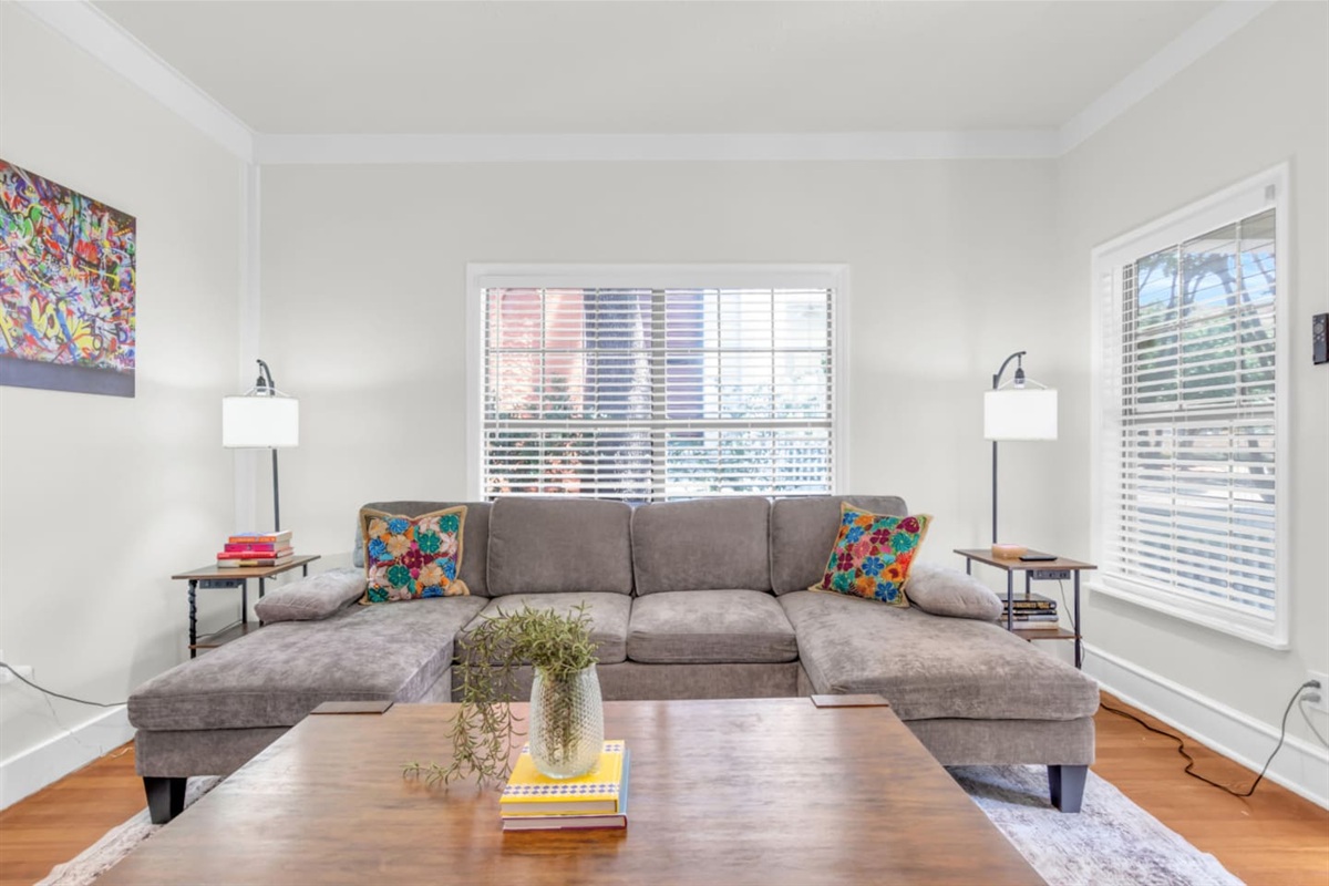 Bright living room with sectional sofa, TV,  and natural light.