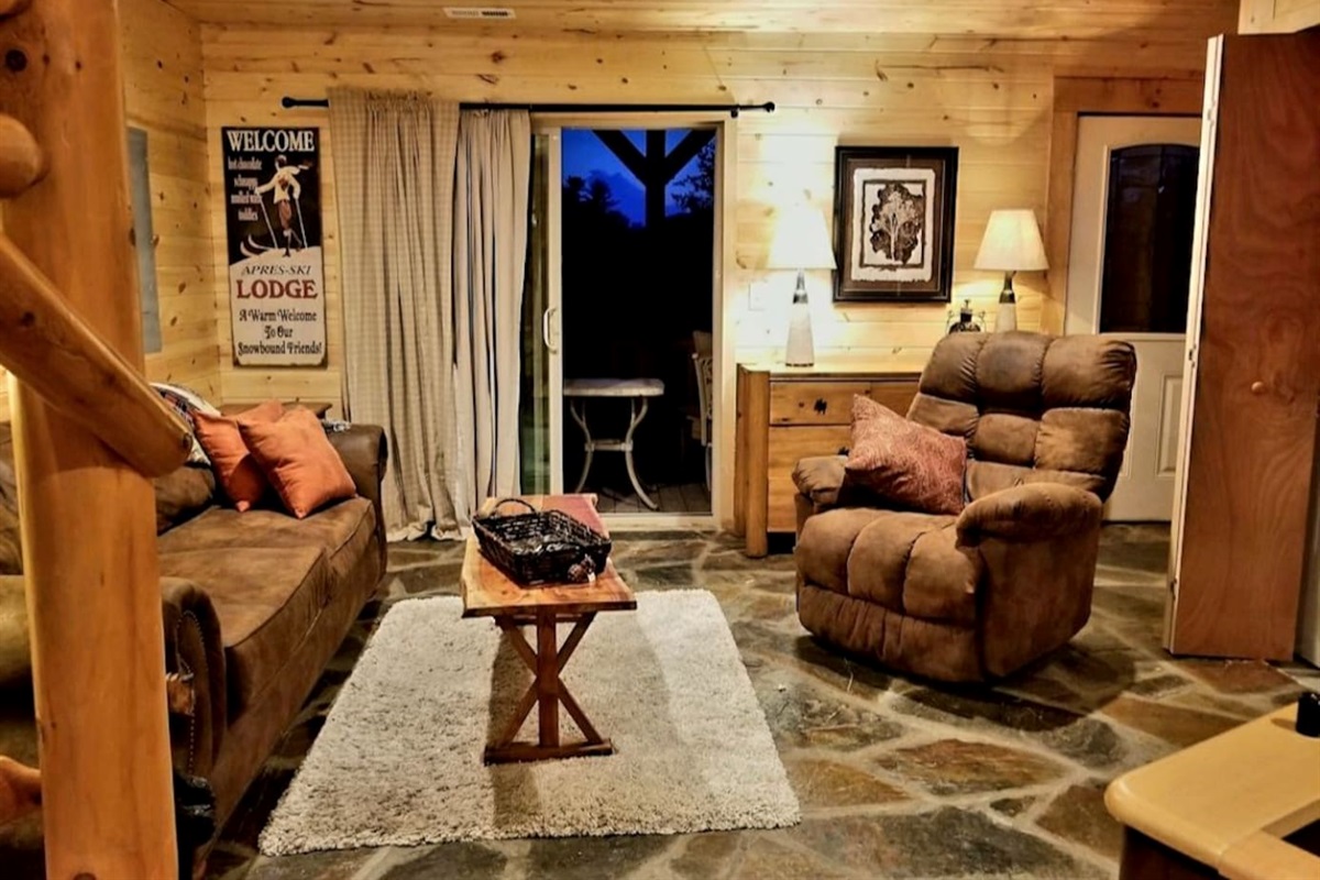 Lower-Level  living room/ game area with large flat screen tv, foos ball table/games- doors to lower , fully enclosed deck with seating and exit gate - with mountain/river views!