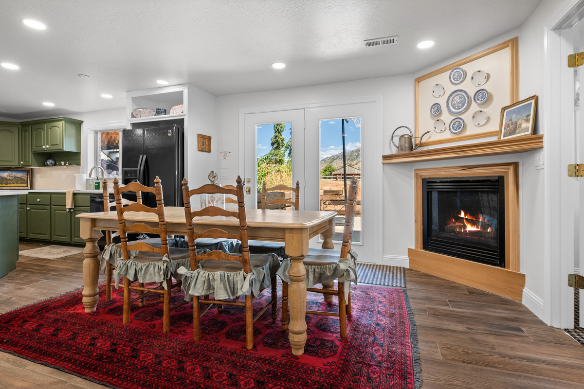 Gather around the dining table beside the fireplace, with direct outdoor access and a seamless connection to the secondary kitchen.