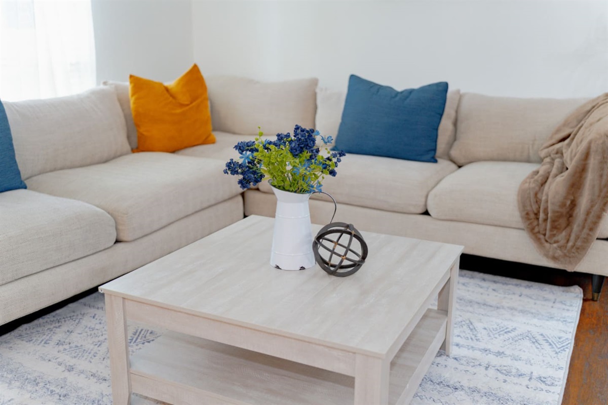 Bright living area with sectional sofa and chic table decor.