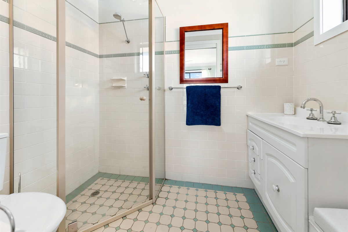 This upstairs bathroom includes a shower, vanity and toilet, giving the main bedroom level a practical bathroom setup.