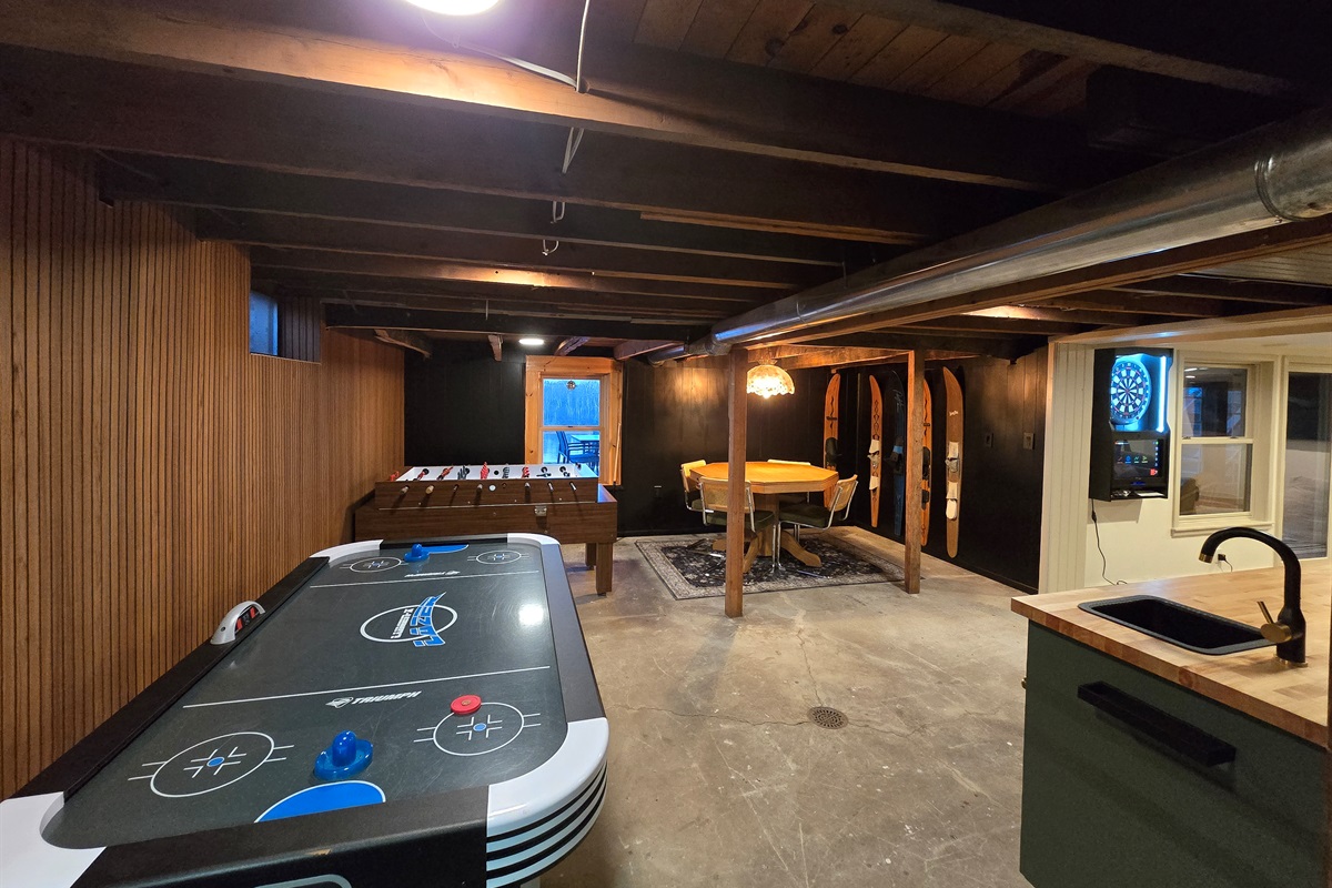 Endless fun awaits in this game-filled basement!  Air hockey, foosball, darts, and a cozy table for chats—your perfect getaway spot! 
