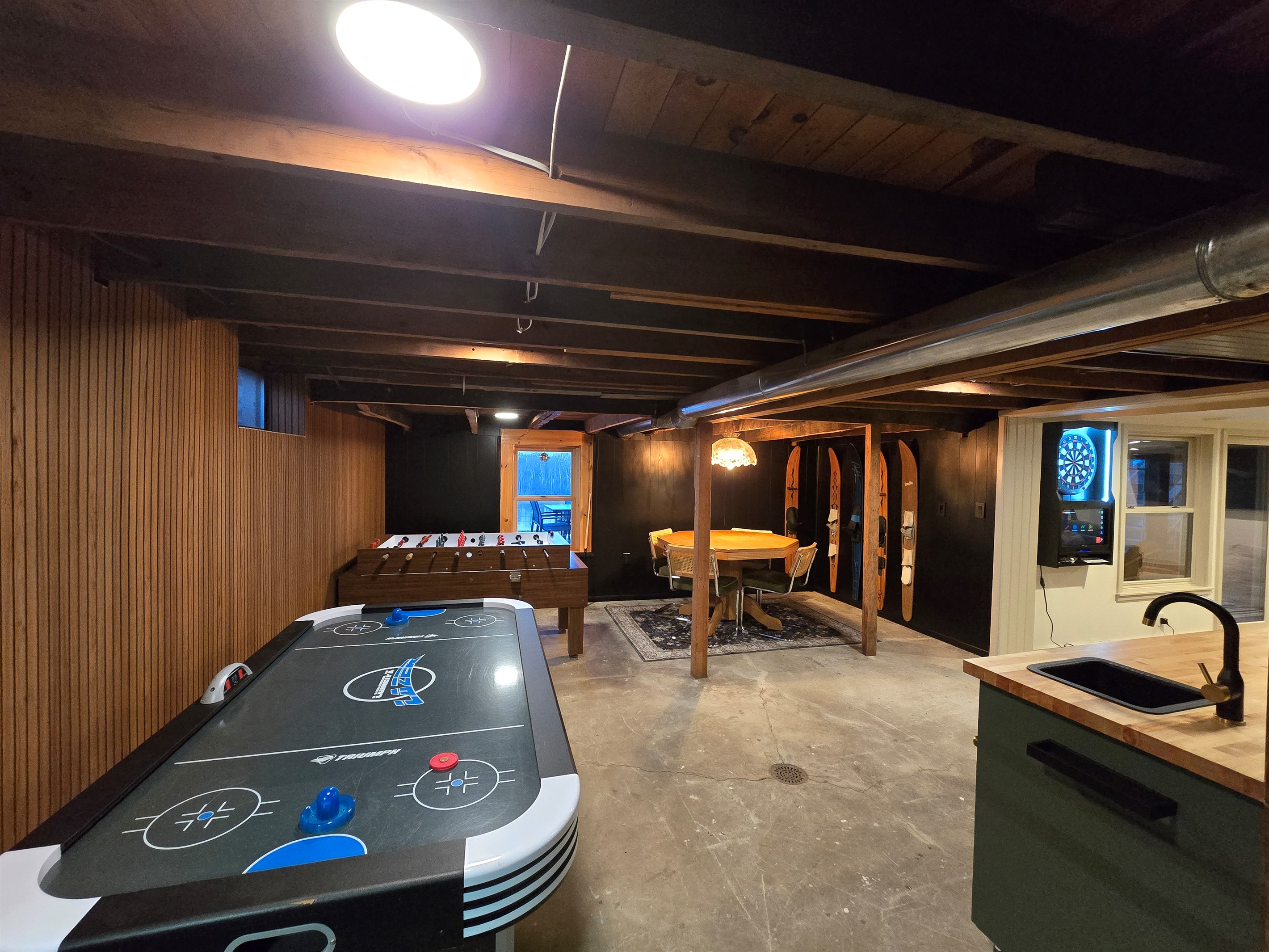 Endless fun awaits in this game-filled basement!  Air hockey, foosball, darts, and a cozy table for chats—your perfect getaway spot! 