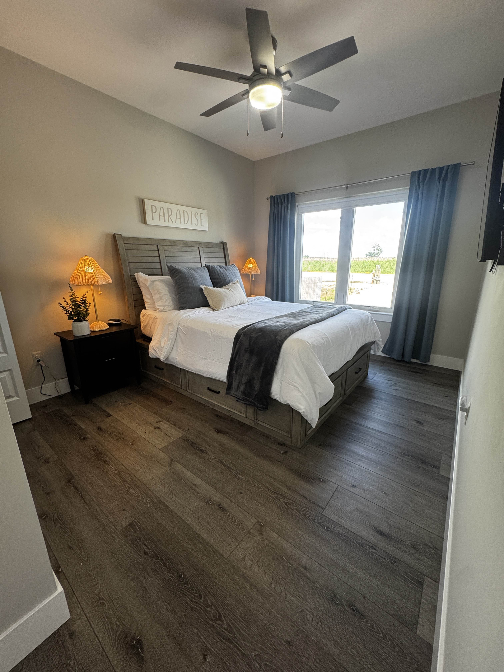 Cozy bedroom featuring a comfortable bed with neutral tones, soft lighting, and large windows offering natural light and peaceful outdoor views—perfect for a relaxing stay.