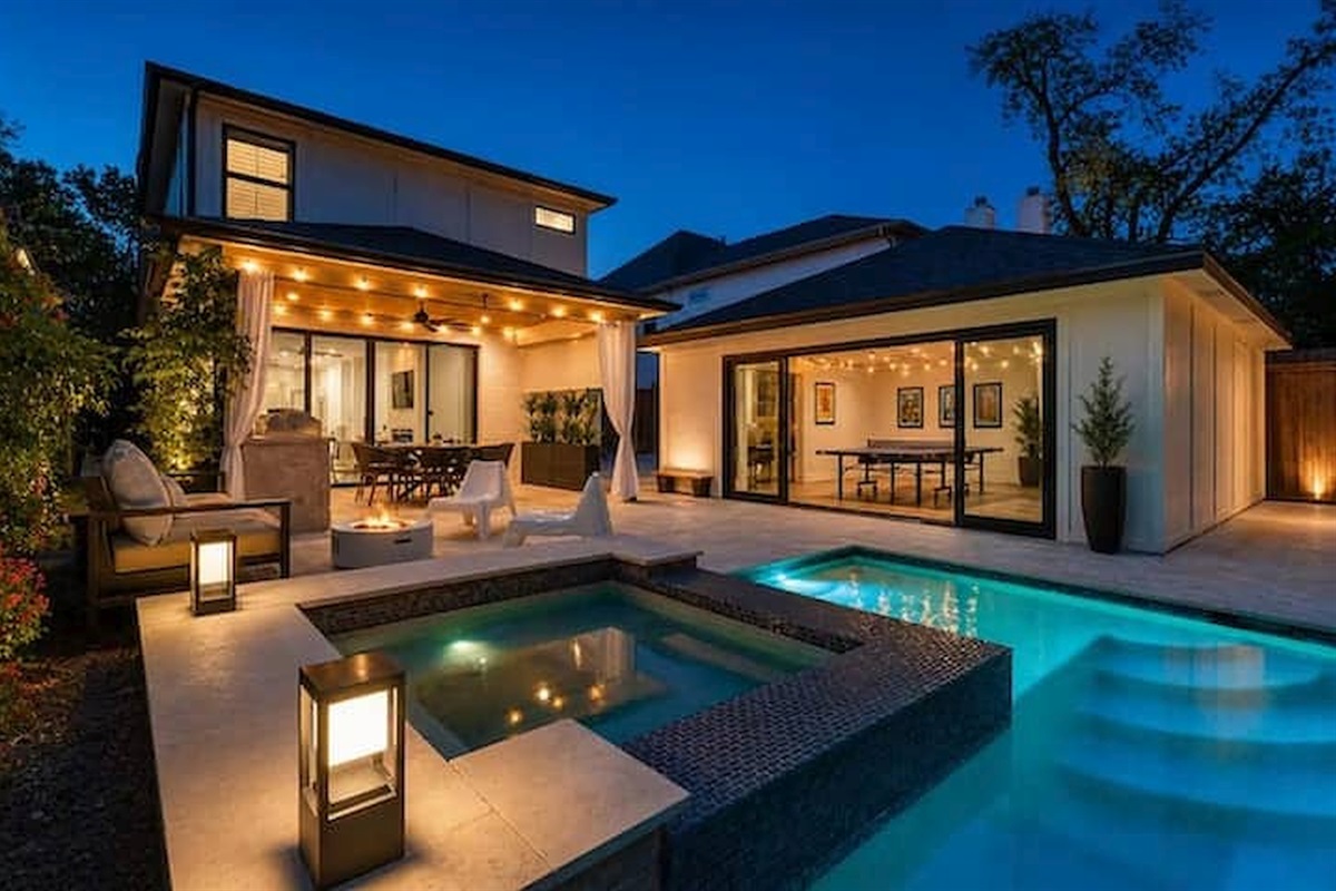 Luxury backyard oasis with glowing pool & lounge areas