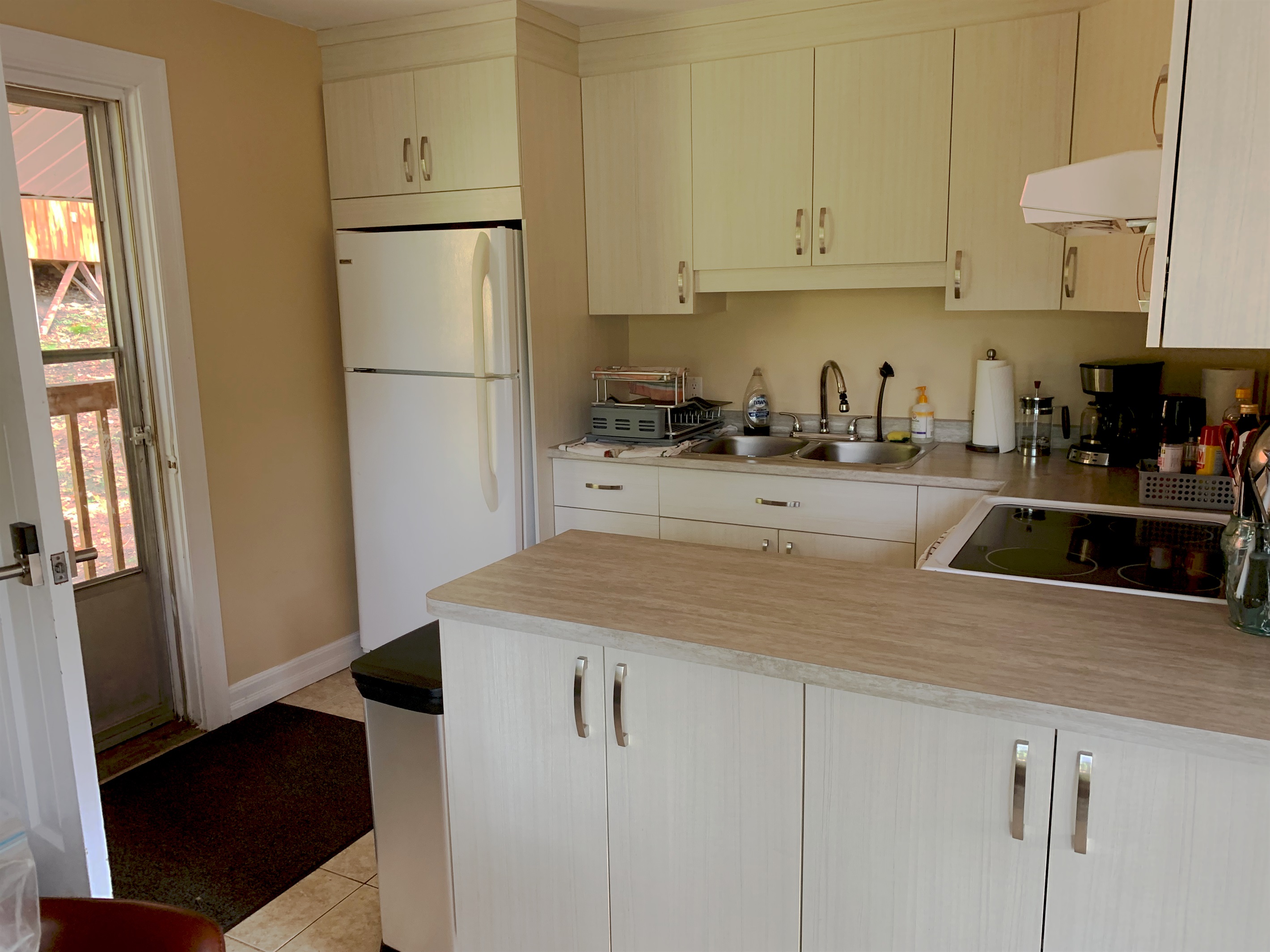 Kitchen showing counters and appliances and main cottage entry door