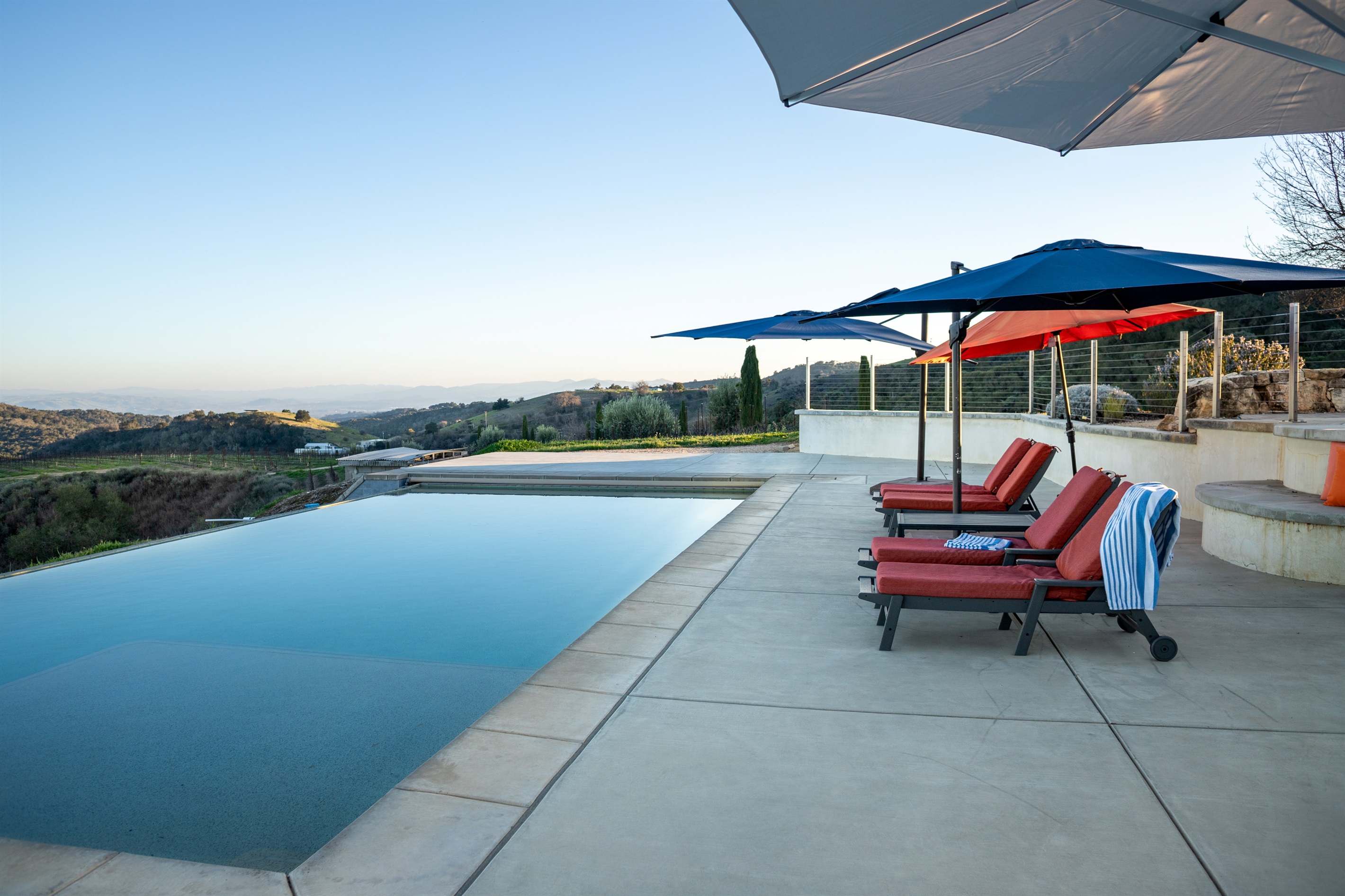 An infinity-edge pool perched above the Adelaida District, looking out over miles of wine country. There are no bad seats at the Hilltop Guest House.