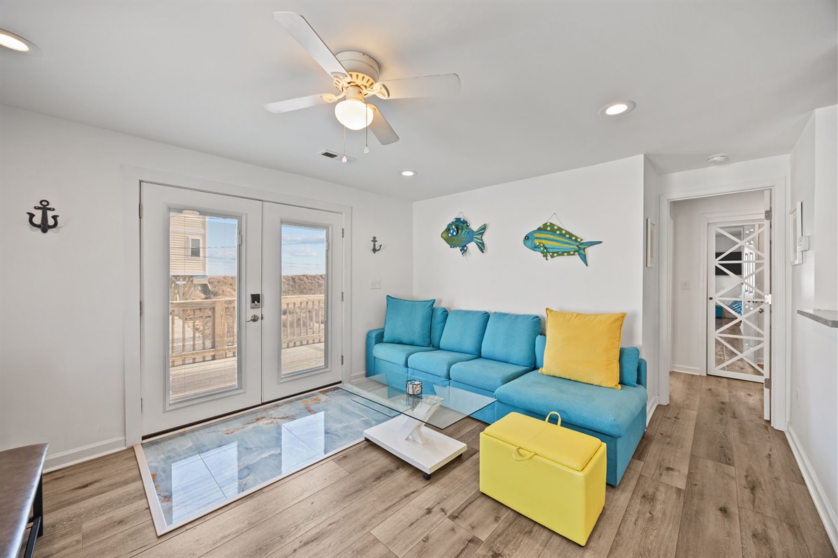 Comfortable seating with a sleeper sofa, coastal accents, and direct access to the deck