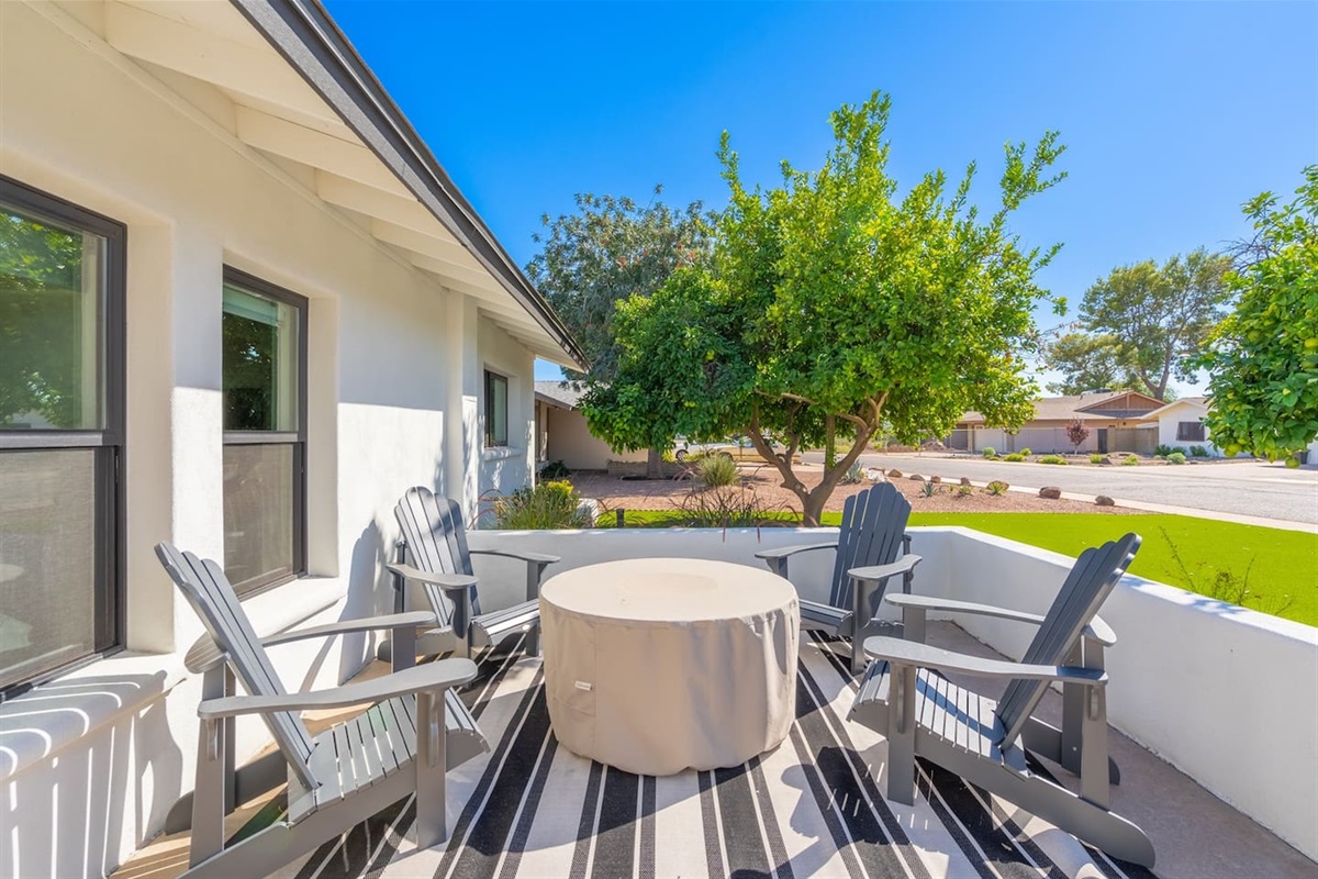 Enjoy the spacious patio featuring comfortable seating arranged around a fire table, perfect for outdoor dining and socializing with family and friends.