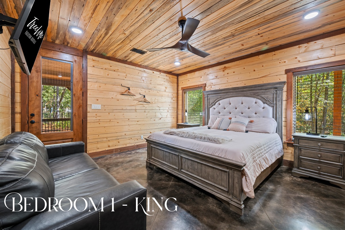 Bright, cozy bedroom with rustic wood walls and peaceful views.