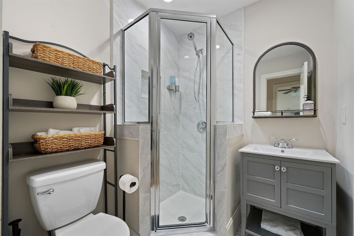 Modern bathroom amenities include a spacious shower stall, clean lines, and essential toiletries.