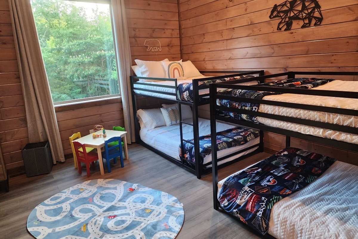 Family-friendly kids’ room with bunk beds, toy table, and cheerful vibes.