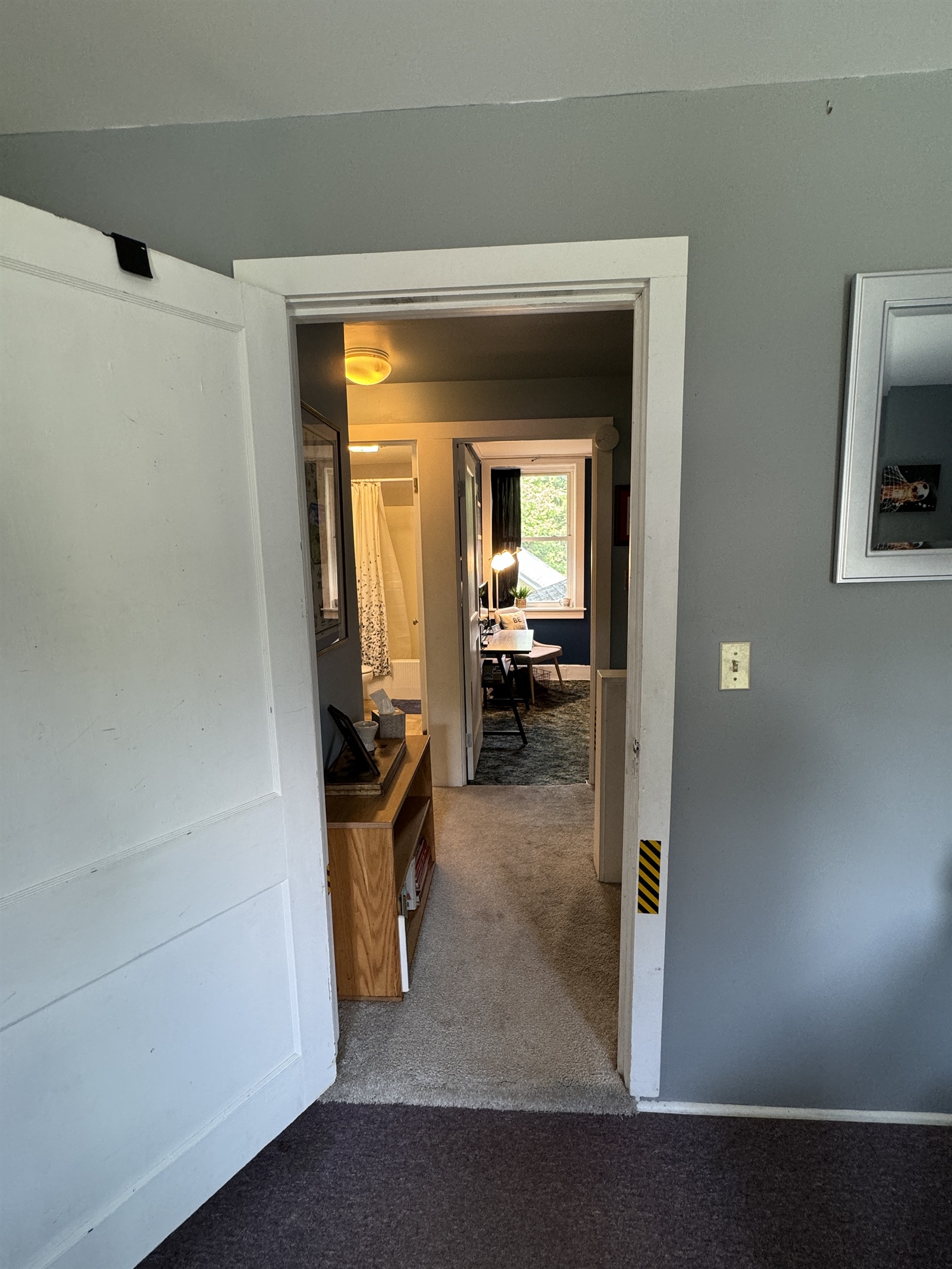 View into the hallway and entry to the full bathroom